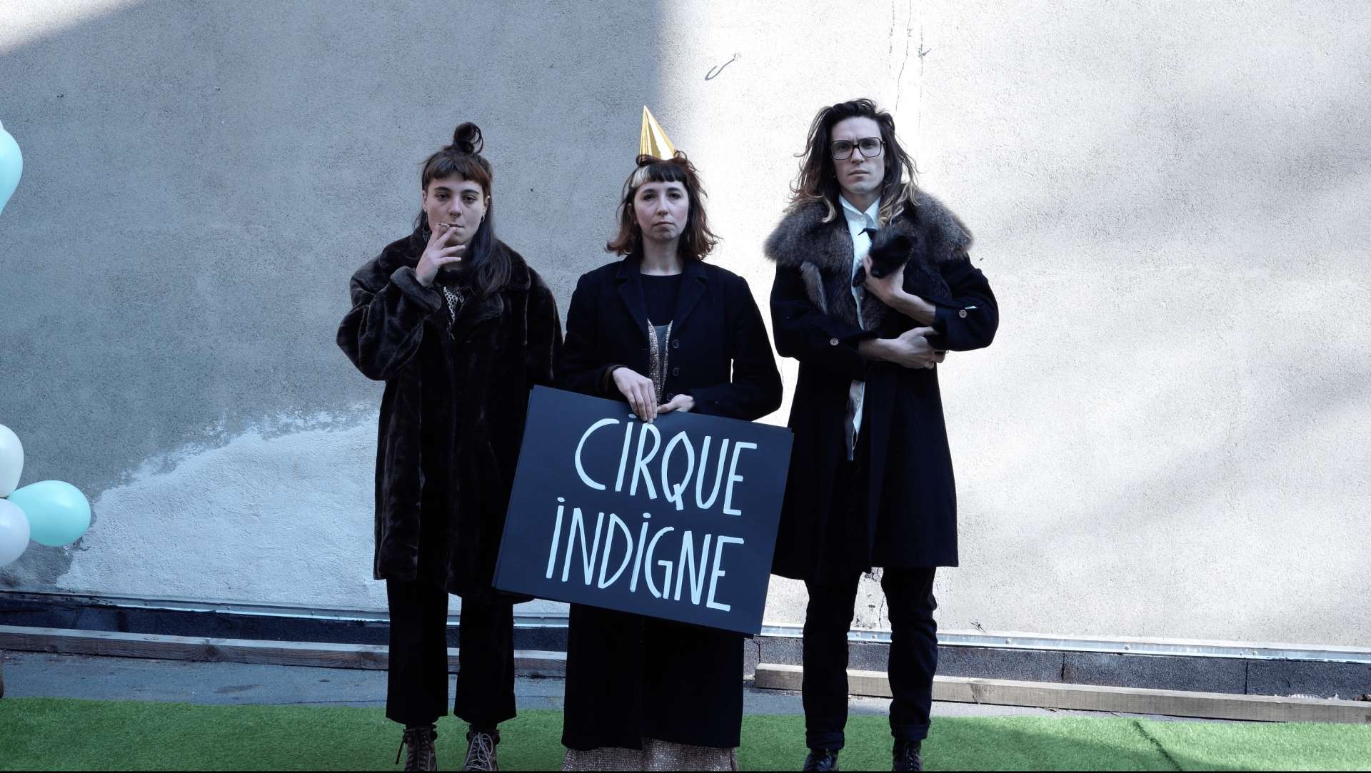 Trois artistes de la compagnie Générale Posthume portent une pancarte sur laquelle il est marquée cirque indigne